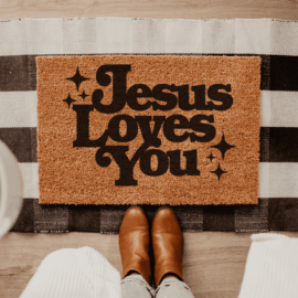 Rustic-style doormat with the phrase “Jesus Loves You” written in bold, elegant lettering, designed to greet guests with a message of faith and love.
