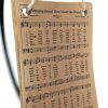 Rectangular ornament with an antique style hymnal page of "Amazing Grace" on it. The ornament is hanging by twine from a black ornament stand.