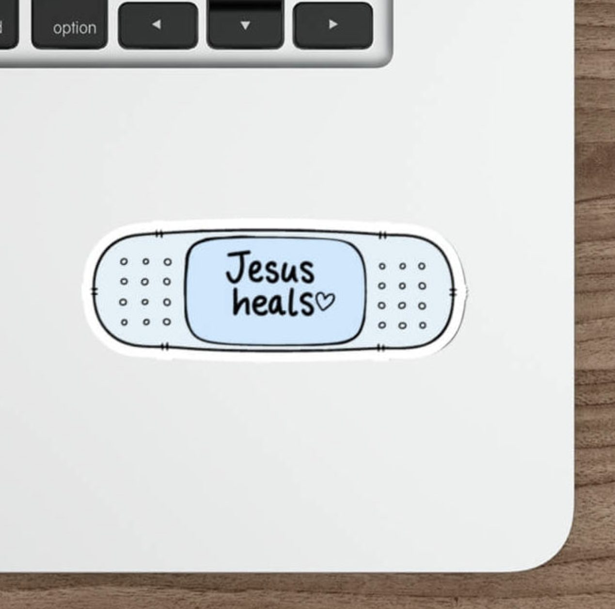 Cute blue Christian bandage sticker featuring the words Jesus Heals with a small heart in a simple kawaii design.